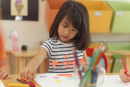 幼儿园教室学龄前和儿童教育概念中的女孩绘画彩色铅笔图片