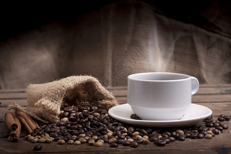 木桌上的咖啡杯和茶托深色背景图片