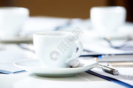 用附近的笔和纸在桌子上特写一杯茶或咖啡图片