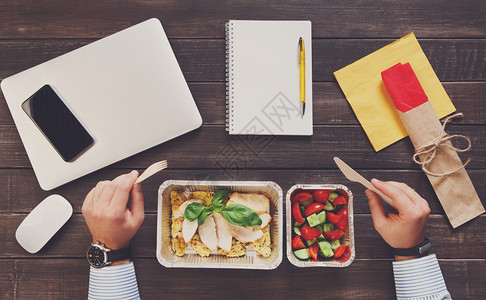 工作中的健康饮食在办公室的商人健康的食品装在铝盒里图片
