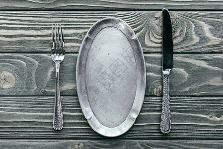 木桌上带餐具的银盘图片