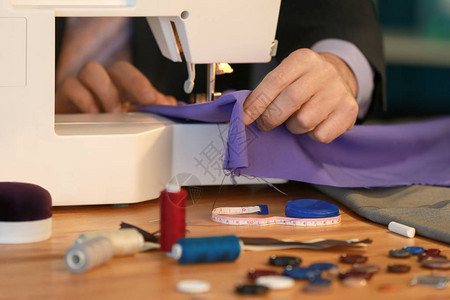 缝纫机的特制裁缝衣在餐具背景图片