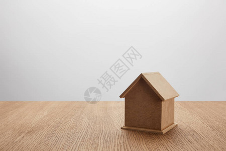 灰色木制表格上小型房屋模型的近图片