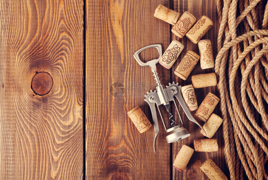 葡萄酒软木塞和开瓶器在质朴的木桌背景带复制图片