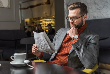 正式的时装男子坐在餐桌边和餐馆阅读报背景图片