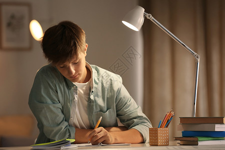 十几岁的男孩晚上在家做作业图片