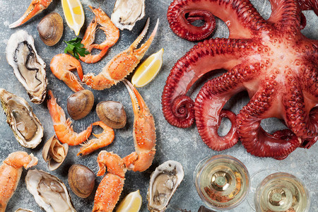 海鲜章鱼牡蛎龙虾蛤蜊和白葡萄酒石桌上的顶视图图片