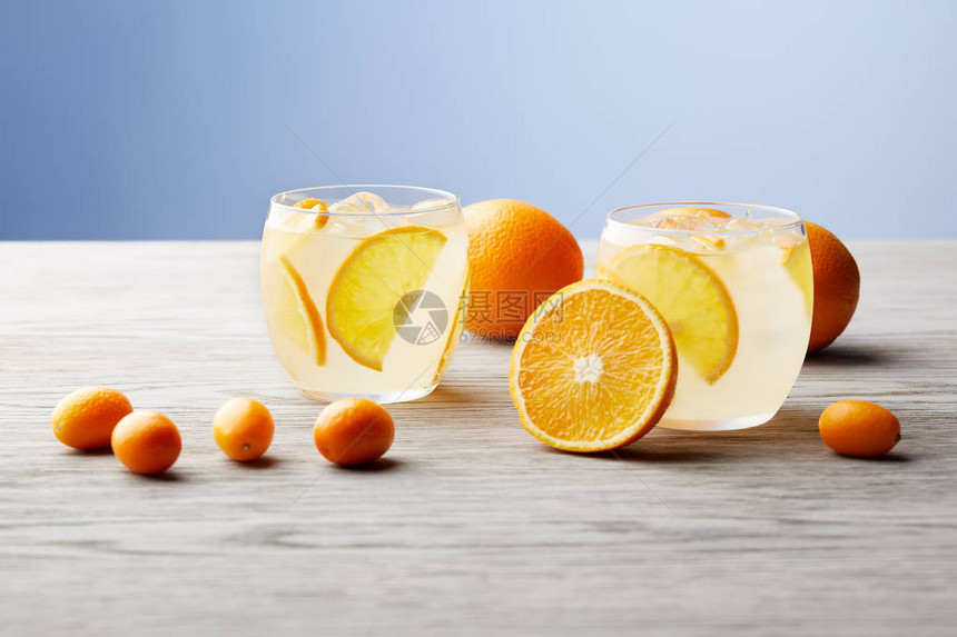 在木桌上放着一杯美味的柠檬水和成熟的橙子图片
