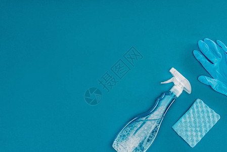 喷雾瓶和橡胶手套的顶部用蓝色隔图片