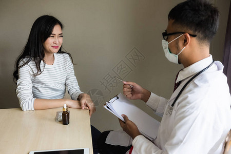 亚洲医生用健康记录文件诊断病人妇女正在医院交谈医疗保图片