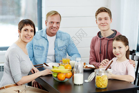 健康家庭成员在厨房桌前吃早图片