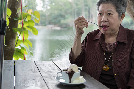 年长者在咖啡馆吃巧克力熔岩蛋糕和香草冰淇淋在餐厅坐着吃甜图片