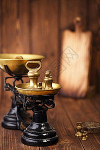 老式铸铁厨房秤旧木桌上有砝码背景图片