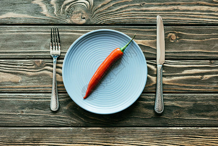 红辣椒用刀和叉在木制桌上将红辣图片