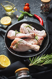 生的鸡腿石板上的鸡腿带烹饪材料的肉图片
