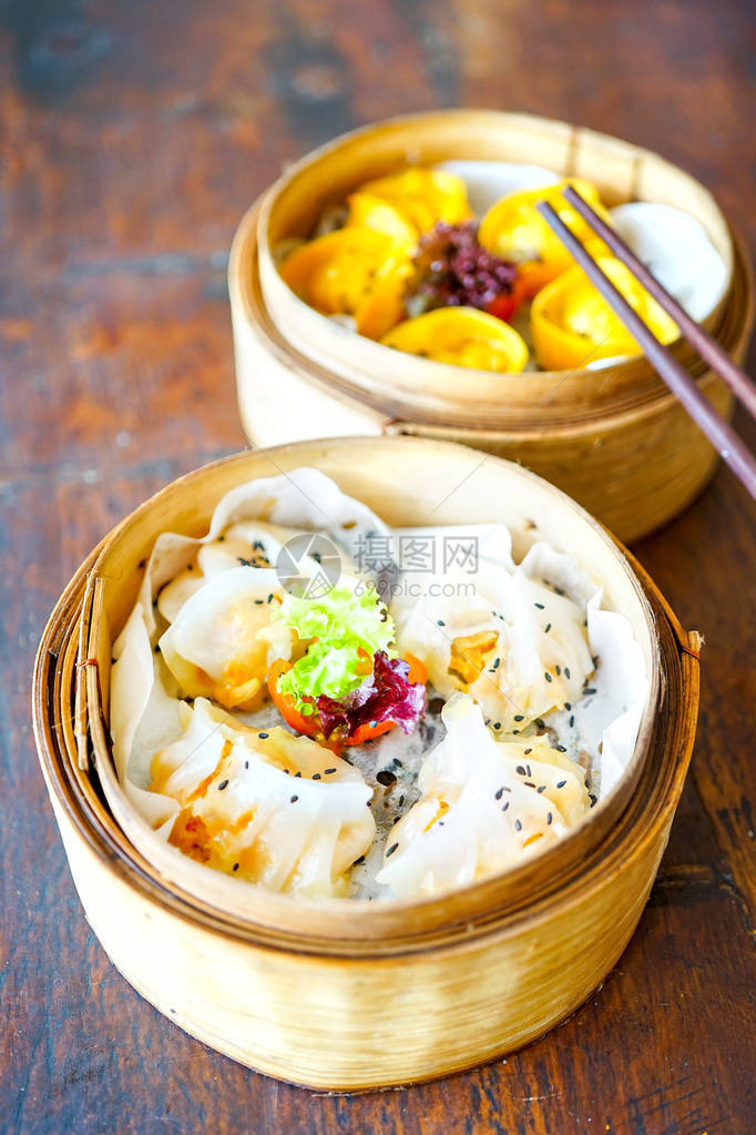 虾无麸质咖喱鸡蒸饺有筷子的手拿着一块在一家餐馆的木桌背景传统的菜带复制空图片