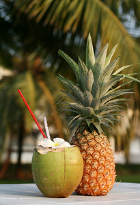 新鲜的椰子饮料和桌上的菠萝图片