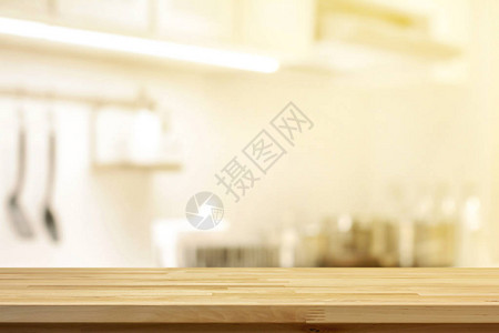 模糊厨房内部背景上的木桌面背景图片
