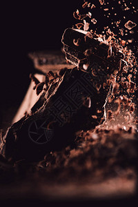 黑色背景的巧克力碎片上掉下来的凝胶巧克力图图片