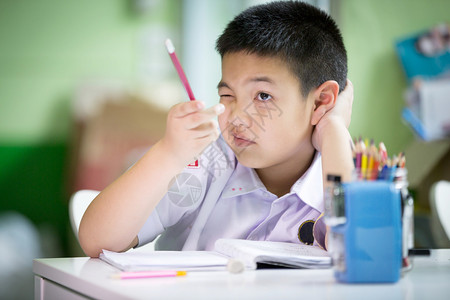 年轻的亚洲男孩在家做作业图片