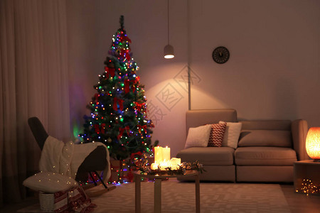 时尚的室内装饰配有蜡烛和装饰圣诞树图片