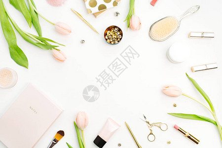 白色背景的粉红色郁金香花饰品和化妆品框架图片