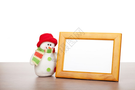 空白照片框和木制桌上的圣诞节雪人白图片
