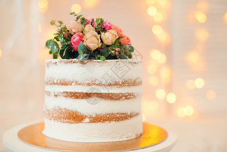 由鲜花所装饰的白裸蛋糕婚礼生日或活动图片