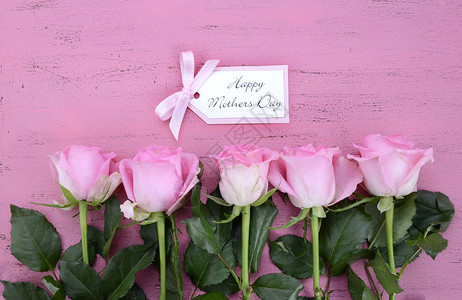 母亲节快乐粉红玫瑰在古典风格的粉红花桌上图片