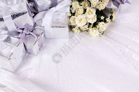 结婚礼物背景和白玫瑰花束放在婚纱带图片