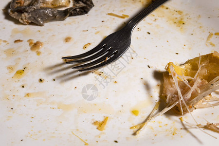 饭后肮脏的盘子叉子和鱼骨头都躺图片