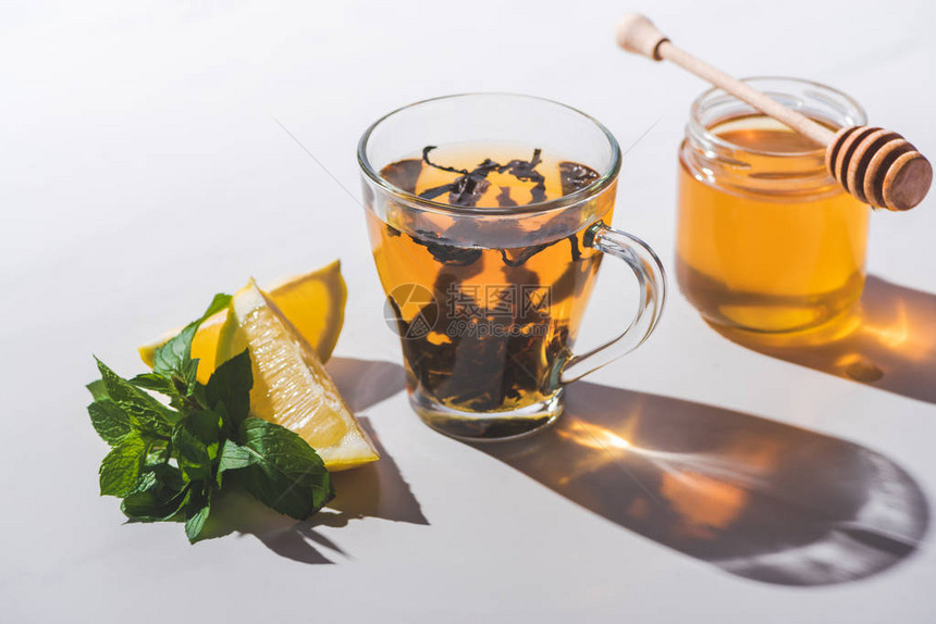 白色桌面杯中的健康红茶加蜂蜜图片