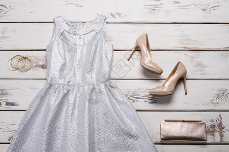 银色晚礼服配饰木架子上的晚装女孩的服装和高跟鞋以折扣价出背景图片