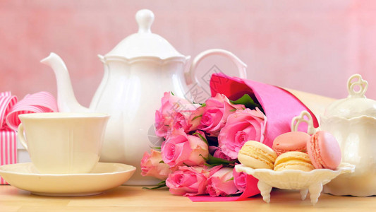 母亲节快乐茶壶的茶叶布置玛卡龙饼干粉背景图片