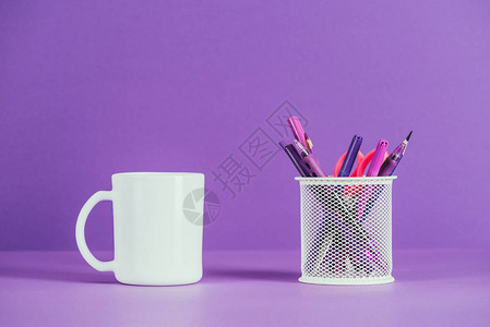紫色表面上的杯和笔架图片