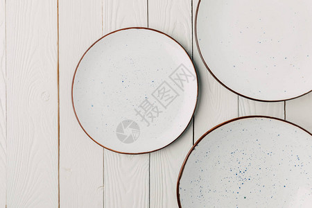 白色木质背景上的陶瓷釉盘背景图片