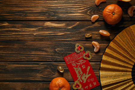 新的成熟的橘子象形字粉扇和木桌金背景