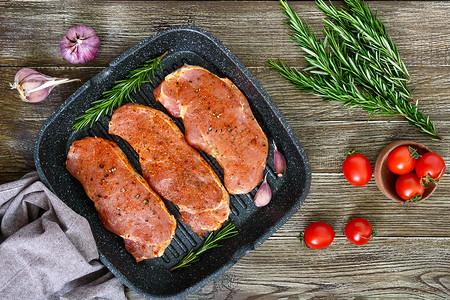 新鲜和生肉沙朗牛排连续准备烹饪用煎锅里的香料腌制的大块生肉图片