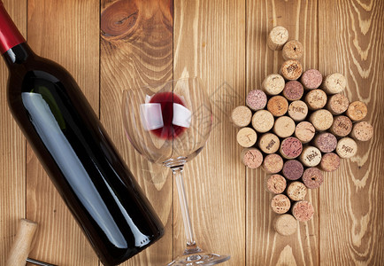 红葡萄酒瓶玻璃和葡萄木图片