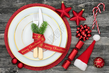 圣诞餐桌盘餐巾餐具冷杉丝带圣诞帽糖果手杖饼干和仿古木背景图片