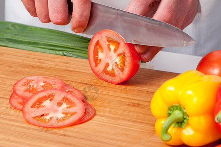 男人的手切番茄沙拉准备图片
