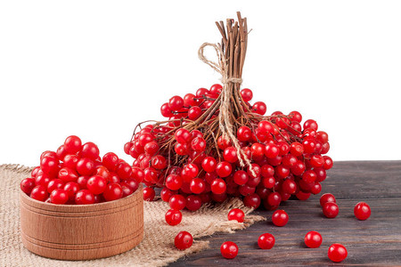 白底桌子上一个木碗里成熟的红生菜莓在白图片