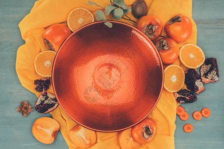 橙色桌布上红色盘子和水图片