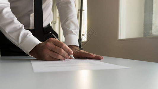 在办公室的商人签署合同文件或法律文件图片