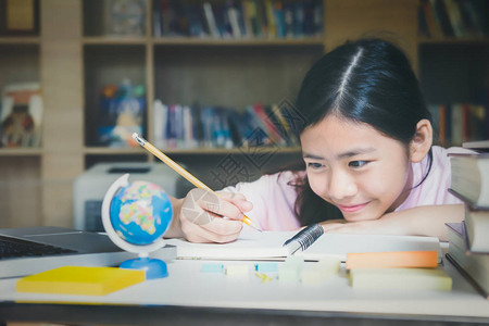 教育理念在学校图书馆读书和写作的女孩学习和学习手头的选择图片