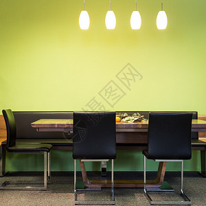 带灯和绿墙的木桌悬臂椅图片