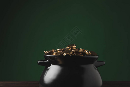 绿色的木桌上的金质硬币图片