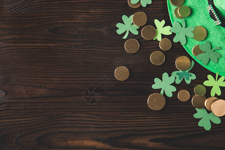 绿色顶的绿色帽子金硬币和木板上的锤子图片