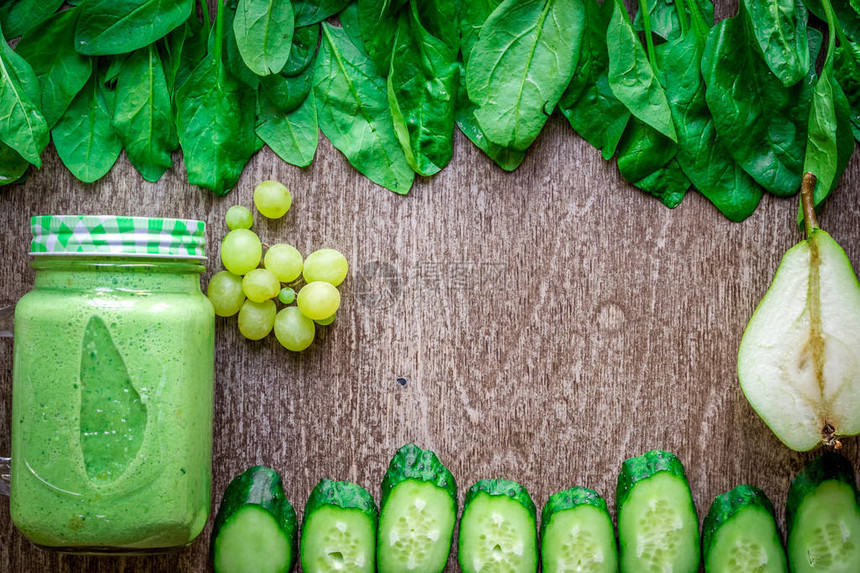 健康的绿色思慕雪与菠菜在一个杯子反对木制背景平躺与文本的地方素食和图片