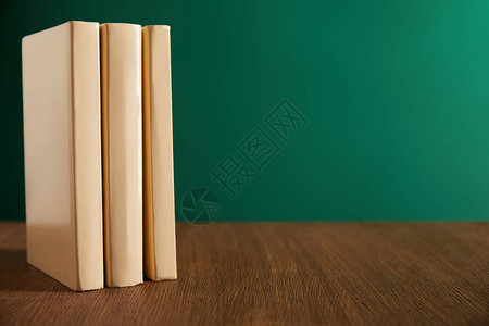 木桌上的三本书背景是黑板背景图片